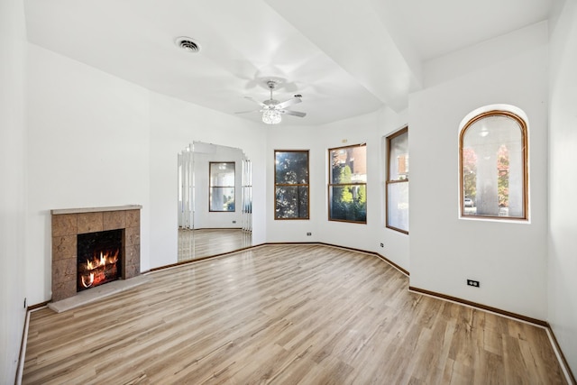 unfurnished living room featuring a fireplace, light wood-type flooring, and ceiling fan