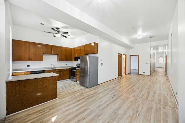 kitchen with ceiling fan, appliances with stainless steel finishes, sink, and light wood-type flooring