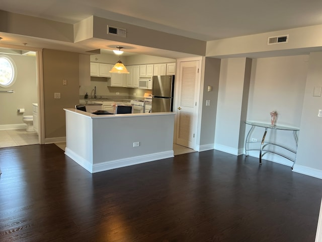 kitchen featuring white cabinetry, dark hardwood / wood-style floors, decorative light fixtures, sink, and white appliances