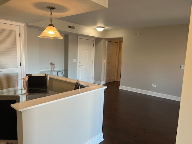 kitchen with pendant lighting and dark hardwood / wood-style flooring