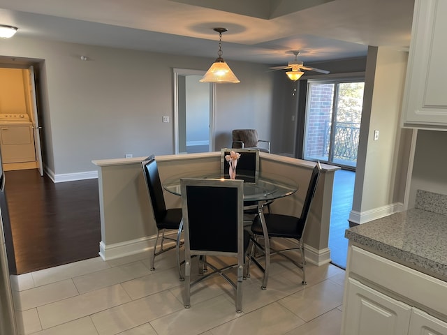 dining space with light hardwood / wood-style flooring, washing machine and dryer, and ceiling fan