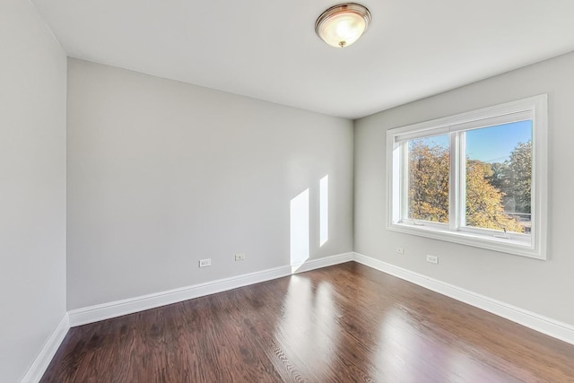 empty room with dark hardwood / wood-style flooring