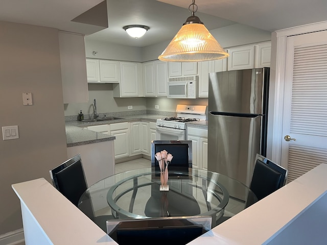 kitchen with white appliances, sink, decorative light fixtures, and white cabinets