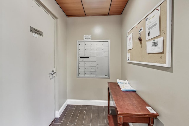 doorway with wood ceiling, a mail area, and dark hardwood / wood-style floors