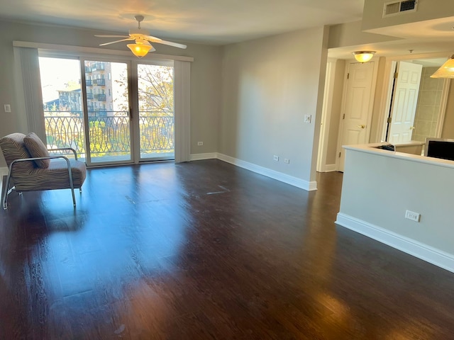 unfurnished living room featuring ceiling fan and dark hardwood / wood-style floors