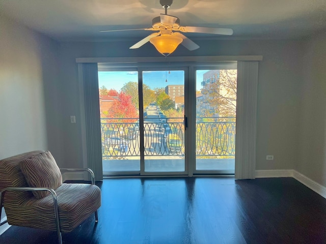 living area featuring wood-type flooring and ceiling fan