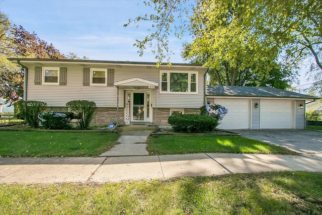 bi-level home featuring a garage and a front lawn