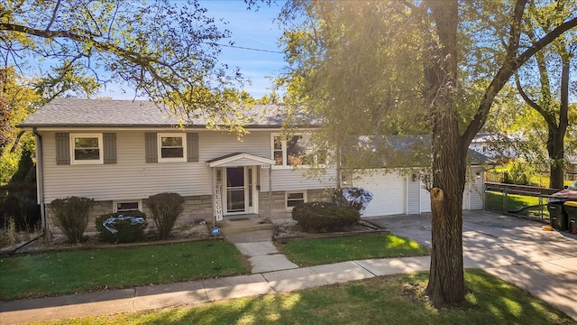 split foyer home featuring a front yard and a garage