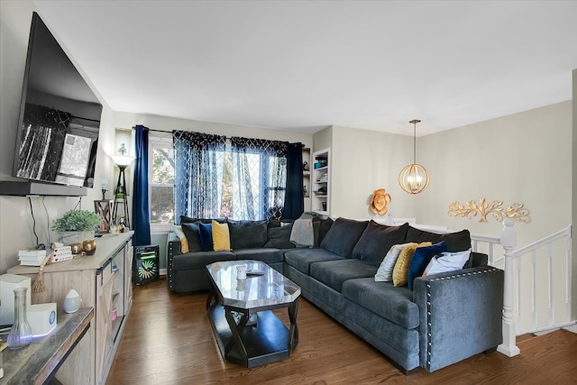 living room with a notable chandelier and dark wood-type flooring