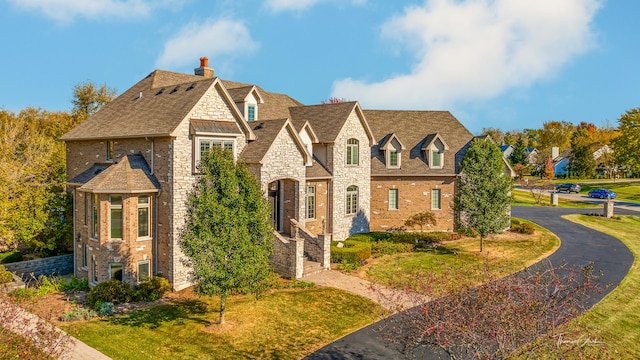 tudor home with a front lawn