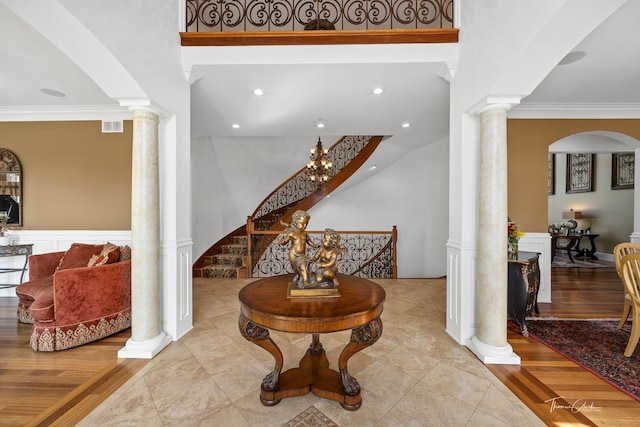 entrance foyer featuring crown molding and ornate columns