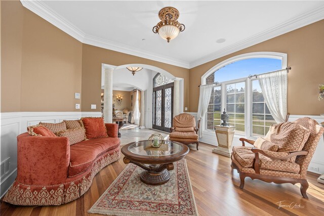 living room with light hardwood / wood-style flooring, ornamental molding, and decorative columns