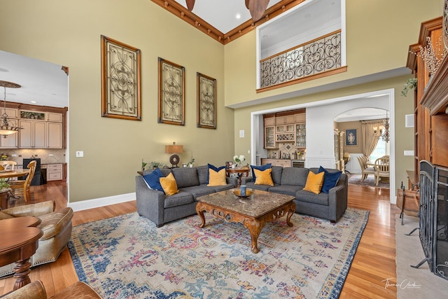 living room featuring a notable chandelier, light hardwood / wood-style floors, and a high ceiling