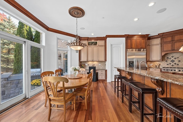 dining space with crown molding, dark hardwood / wood-style floors, and sink