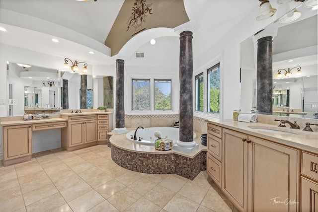 bathroom with ornate columns, lofted ceiling, tile patterned flooring, vanity, and a relaxing tiled tub