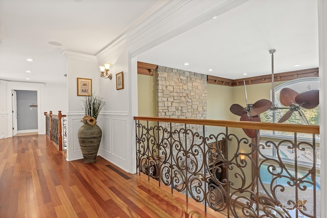 hall with wood-type flooring and ornamental molding