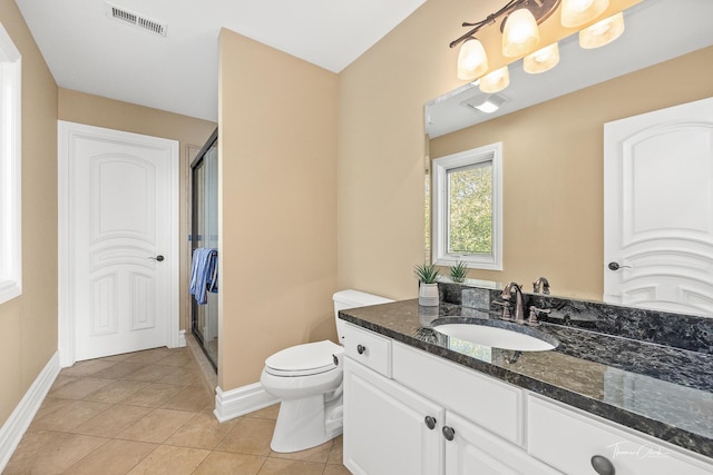 bathroom with vanity, toilet, an enclosed shower, and tile patterned flooring