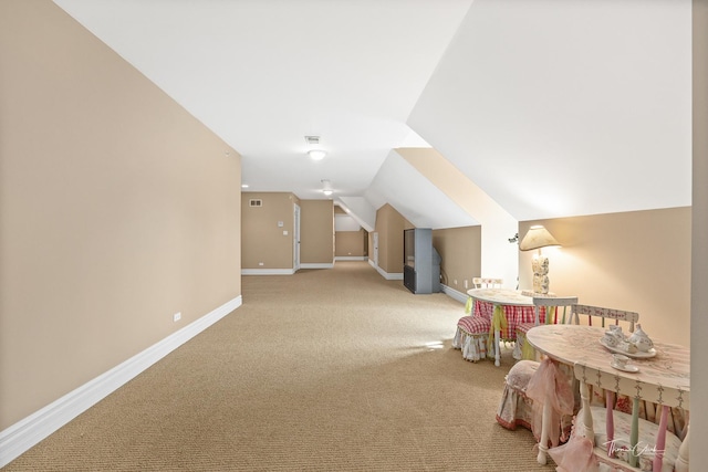 bonus room featuring vaulted ceiling and light colored carpet