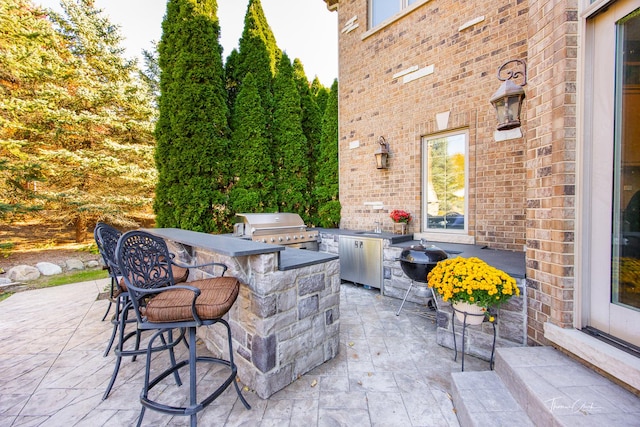 view of patio featuring exterior kitchen, grilling area, and a bar