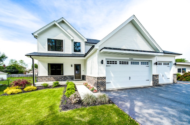 view of front of property featuring a garage, a front yard, and a porch