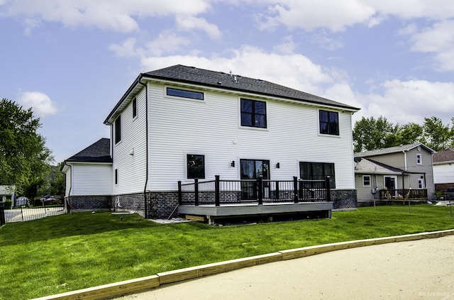 rear view of property featuring a lawn and a wooden deck