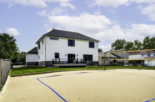 back of property with a lawn and volleyball court