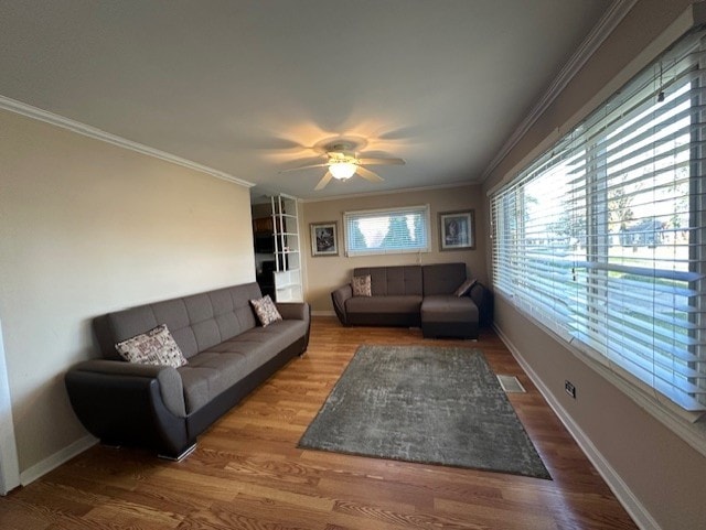 living room featuring ceiling fan, wood-type flooring, and ornamental molding