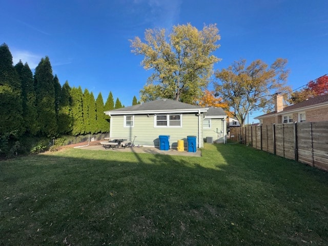 rear view of house featuring a patio and a lawn