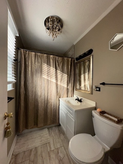 bathroom with a textured ceiling, toilet, vanity, crown molding, and curtained shower