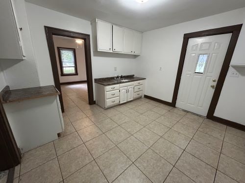 kitchen with white cabinetry and light tile patterned flooring