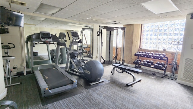 exercise room featuring a drop ceiling and carpet floors