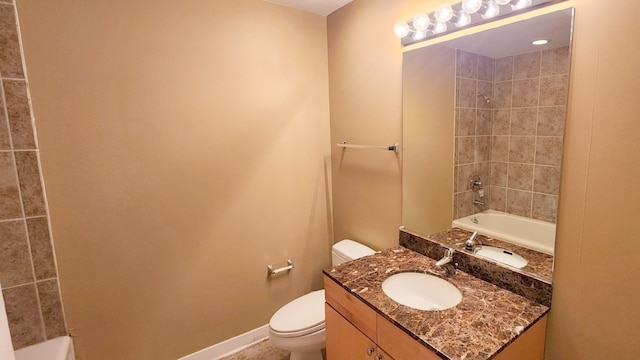 full bathroom featuring toilet, tiled shower / bath, and vanity