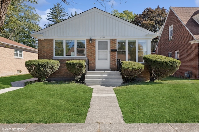 bungalow-style home with a front lawn