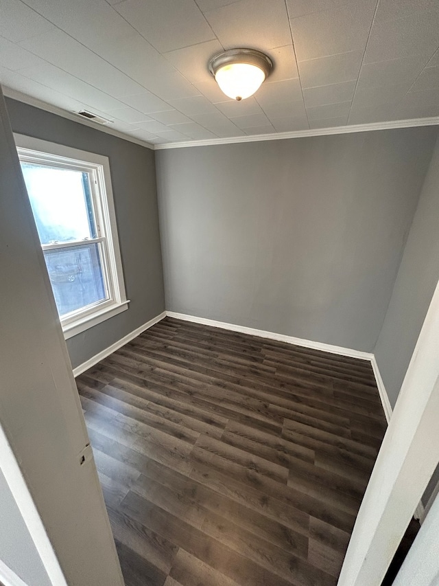 unfurnished room featuring ornamental molding and dark hardwood / wood-style flooring