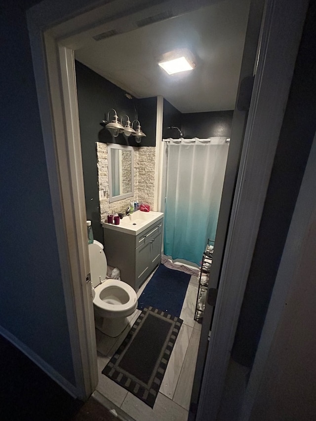 bathroom with vanity, toilet, tile patterned floors, and a shower with shower curtain