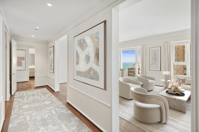 hallway with hardwood / wood-style floors and crown molding