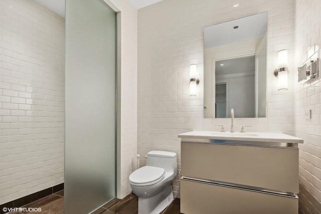 77 E Walton St Unit 28B, Chicago, IL 60611 - full bathroom with tile walls, toilet, vanity, wood finished floors, and a walk in shower