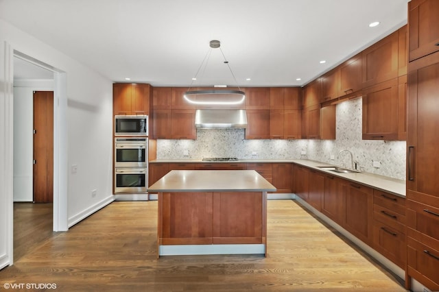 77 E Walton St Unit 28B, Chicago, IL 60611 - kitchen featuring stainless steel appliances, a sink, light wood-style floors, wall chimney exhaust hood, and decorative backsplash