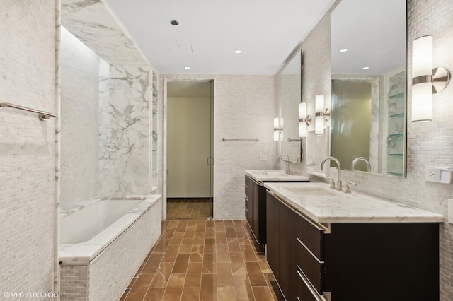 77 E Walton St Unit 28B, Chicago, IL 60611 - bathroom with a bath, two vanities, and recessed lighting