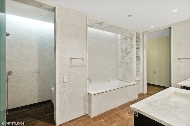 bathroom featuring vanity and tiled tub