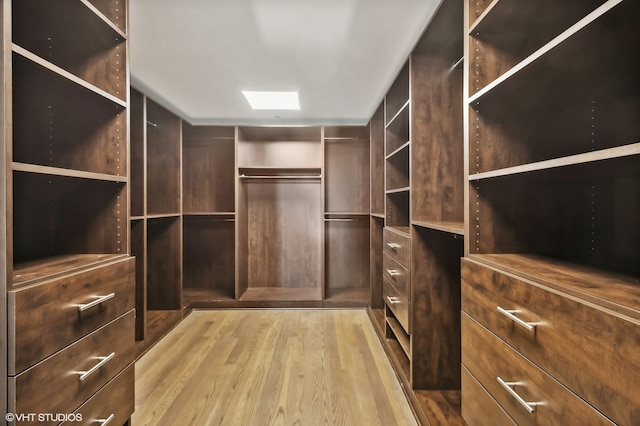 walk in closet with light hardwood / wood-style flooring