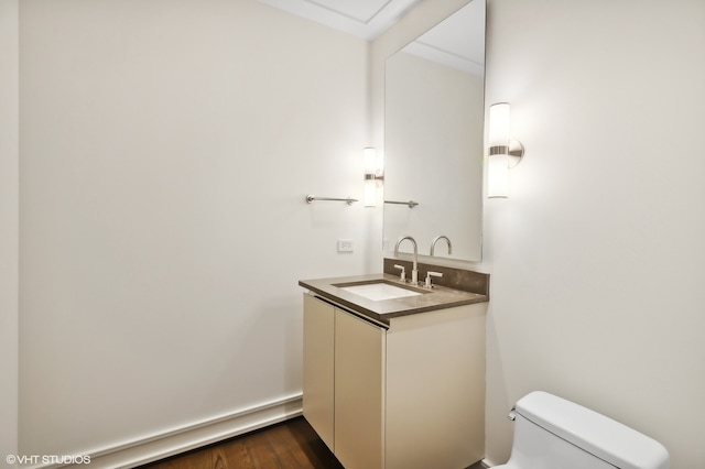 bathroom with hardwood / wood-style floors, vanity, and toilet