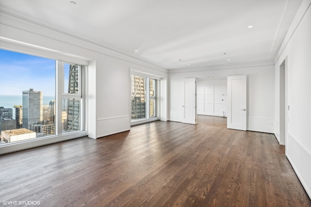 unfurnished living room featuring crown molding, a healthy amount of sunlight, and dark hardwood / wood-style floors