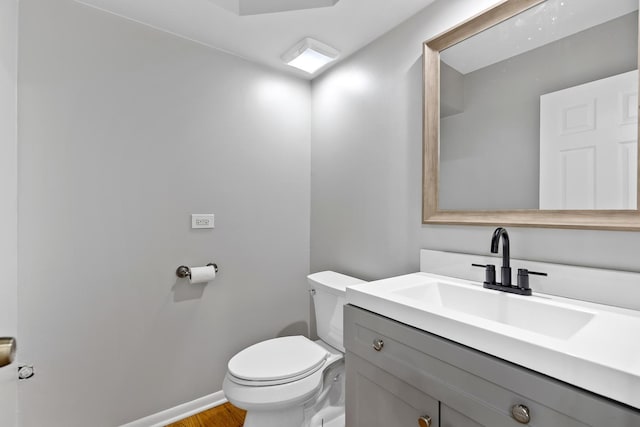 bathroom featuring hardwood / wood-style flooring, toilet, and vanity