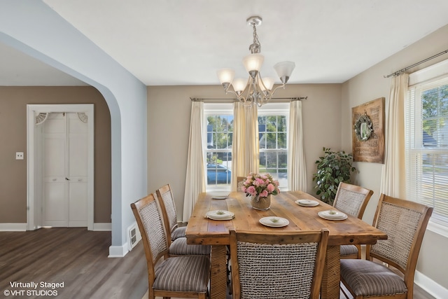 dining area featuring dark hardwood / wood-style floors and an inviting chandelier