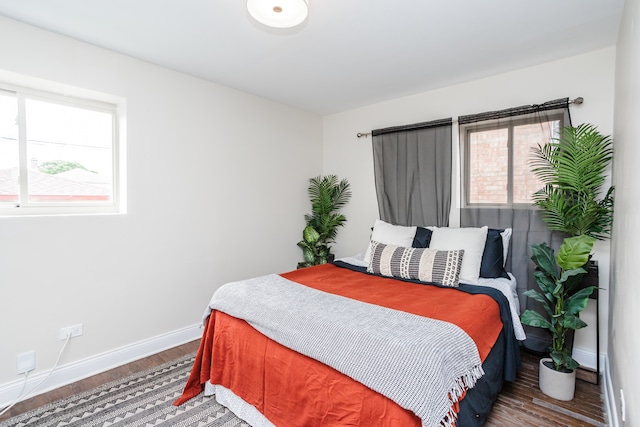 bedroom with multiple windows and hardwood / wood-style floors