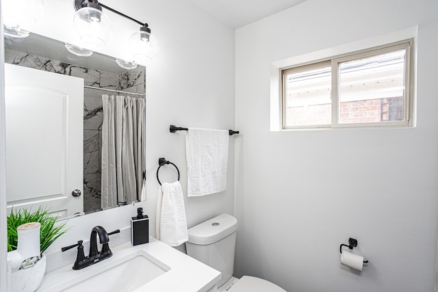 bathroom with vanity, curtained shower, and toilet