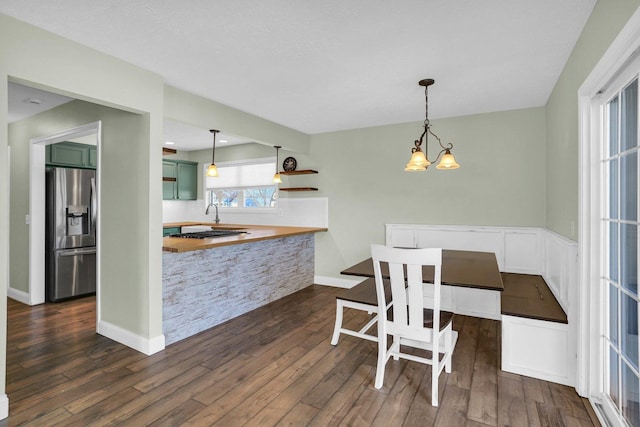 dining room with dark hardwood / wood-style floors and an inviting chandelier