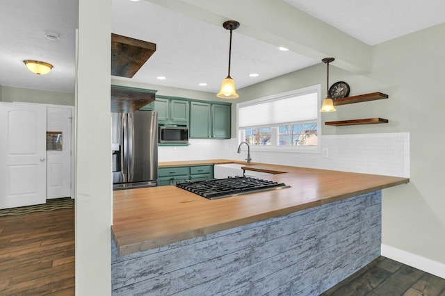 kitchen featuring dark wood-type flooring, wooden counters, kitchen peninsula, and appliances with stainless steel finishes