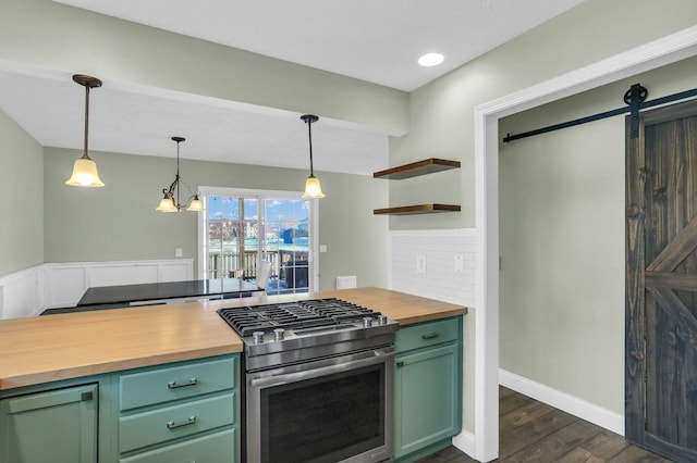 kitchen with stainless steel gas range, green cabinets, wood counters, decorative light fixtures, and a barn door